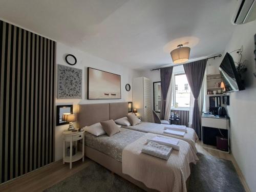 a bedroom with a large bed and a window at Apartment Agora in Zadar
