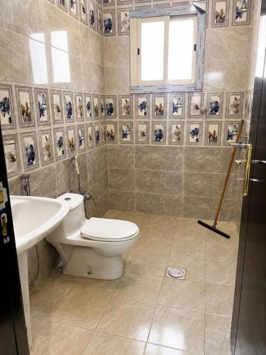 a bathroom with a toilet and a sink at البساتين هومز - Al Basateen Homes in Al Baha