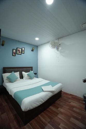 a bedroom with a large bed with blue walls at The Highstreet Legacy in Pune