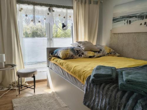 a bedroom with a bed with yellow sheets and a window at Agroturystyka Zdrowo przez sad in Brzezinki