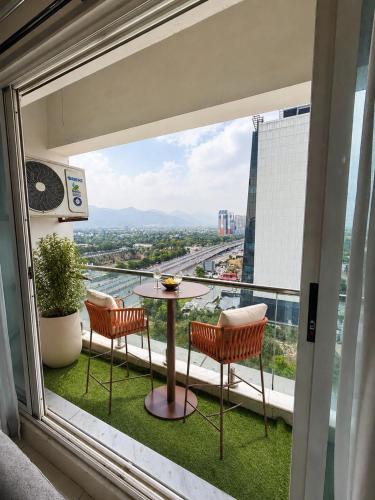 a balcony with a table and chairs and a view at 1BR Luxury Apartments With Balcony & Mountains View In Elysium Tower OPP Centaurus Mall Islamabad in Islamabad