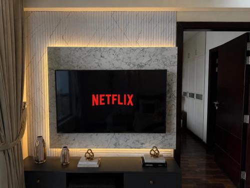 a television with the netflix sign on a wall at 1BR Luxury Apartments With Balcony & Mountains View In Elysium Tower OPP Centaurus Mall Islamabad in Islamabad