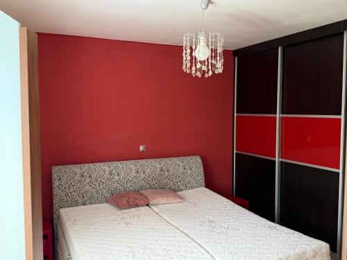 a bedroom with a bed with a red wall at Chata U Druhé pískovny in Roudná