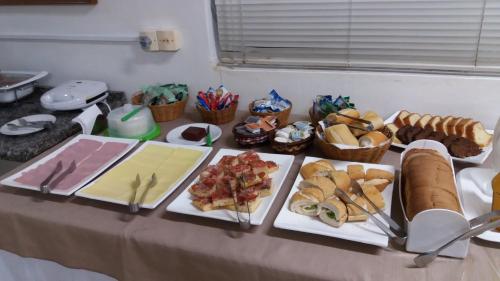 a table with many different types of food on it at Uniflat Hotel Bauru in Bauru