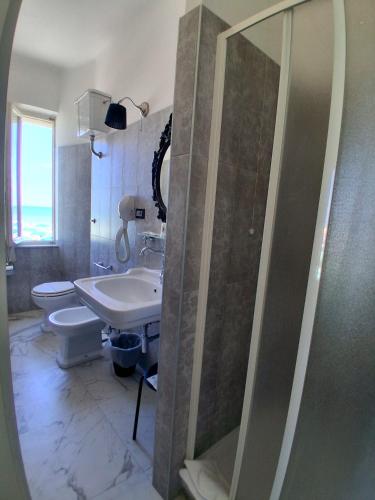 a bathroom with a shower and a sink and a toilet at Albergo Regina in Senigallia