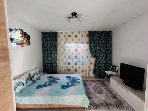 a bedroom with a bed and a flat screen tv at Căsuța de vacanță in Năvodari