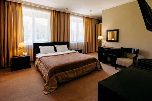 a hotel room with a bed and a chair at Lavina Park Hotel in Dnipro