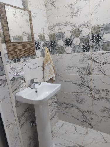 a white bathroom with a sink and a mirror at Beach House Buzovna in Baku