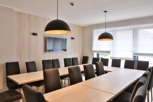a conference room with wooden tables and chairs at Hotel Lantier Wellness & Spa in Bytom