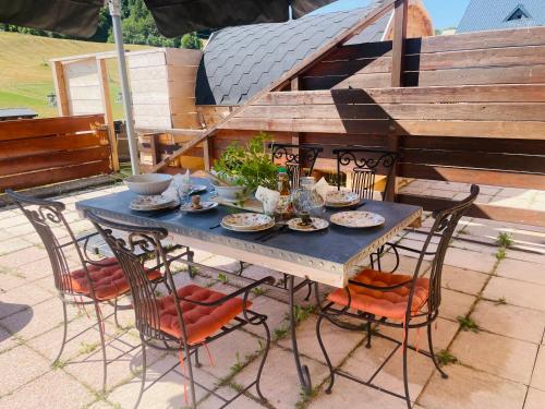 a blue table with chairs and plates of food at Le Logis de Bamby in Ancelle