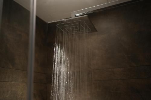 a shower with a stream of water in a bathroom at Jas Grand Homes in Cochin