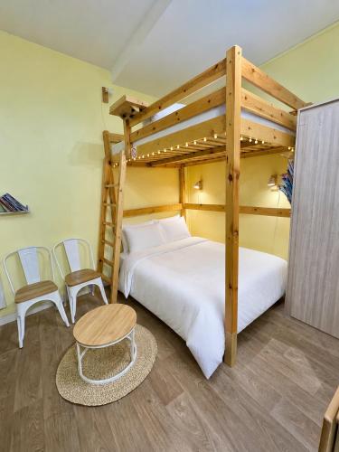 a bedroom with two bunk beds and a table and chairs at Studio le Desman des Neiges - Hyper centre - Proche thermes et télécabine in Cauterets
