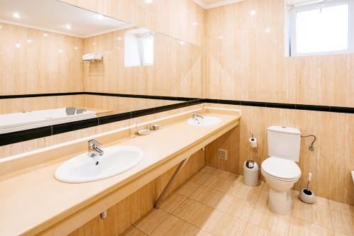 a bathroom with a sink and a toilet and a mirror at Lavina Park Hotel in Dnipro