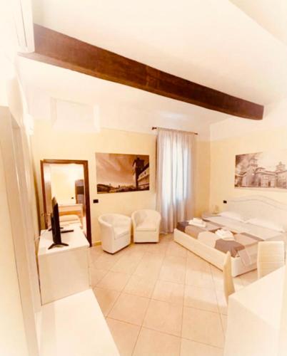 a large living room with white furniture and a mirror at DIMORA AL SARACENO in Ferrara