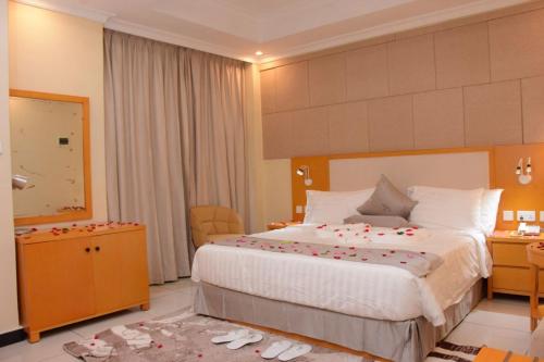 a bedroom with a large bed with roses on it at Diamond Luxury Hotel plc in Desē