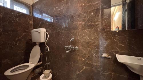 a bathroom with a toilet and a sink at Preet Residency Homestays in Jabalpur