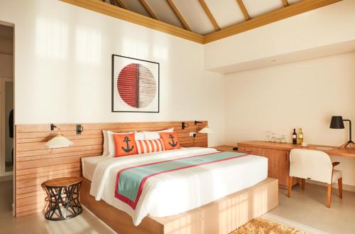 a bedroom with a bed and a desk at Sun Siyam Iru Veli - 24 Hours Premium All Inclusive Dine Around with Free Sea Plane Transfers & Exclusive Inclusions in Dhaalu Atoll