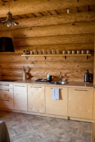 a kitchen with two sinks and a wooden wall at Silmaļi Tērvetē in Tērvete