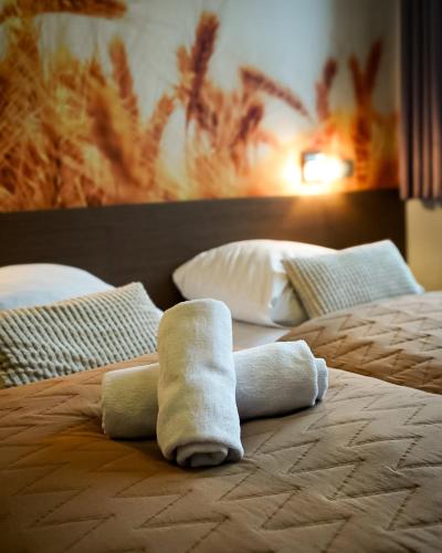 a pair of towels sitting on top of a bed at Stary Młyn in Strzelce Opolskie