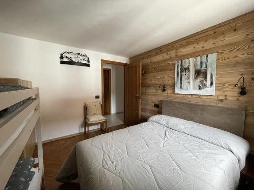 a bedroom with a white bed and wooden walls at Central Spacious Apartment, Mountain Views in Sauze d'Oulx