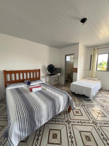 a bedroom with two beds and a tiled floor at Suítes FM in Cavalcante