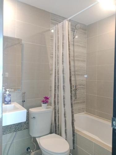 a bathroom with a toilet and a sink and a tub at 8 Newtown boulevard in Punta Engaño