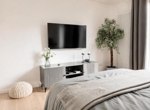 a bedroom with a flat screen tv on a wall at MeinZuhause Apartment EG in Bad Pyrmont