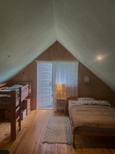 a attic bedroom with a bed and a window at Ventlejas in Strakši