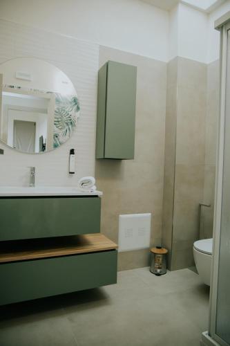 a bathroom with a sink and a mirror and a toilet at Nonno Turiddru Guest House in Marsala