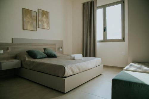 a bedroom with a large bed and a window at Nonno Turiddru Guest House in Marsala