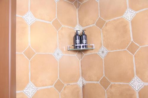 a bathroom with two bottles on a wall at Eden Casa in Mararikulam