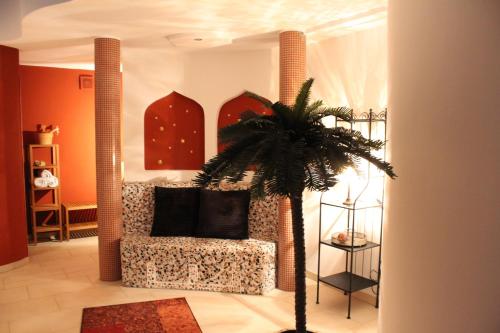 ein Wohnzimmer mit einem Sessel und einer Palme in der Unterkunft Ostalb-Spa in Leinzell