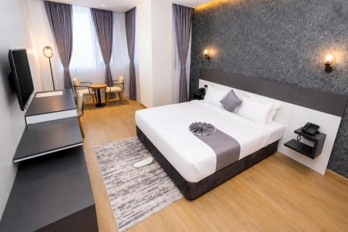 a bedroom with a large white bed and a table at Shitaye Suite Hotel in Addis Ababa