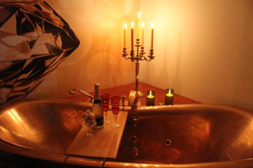 eine Badewanne mit zwei Kerzen und Weingläsern in der Unterkunft Ostalb-Spa in Leinzell