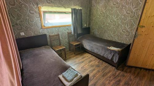 a small room with two beds and a window at Lali`s Guest House in Juta in Jut'a