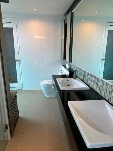 a bathroom with a sink and a large mirror at Yenna Apt in Kamala Beach