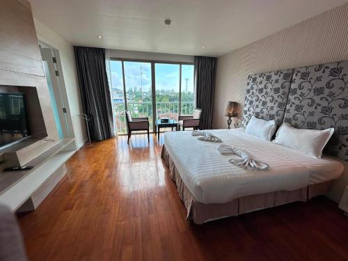 a hotel room with a large bed and a large window at Yenna Apt in Kamala Beach