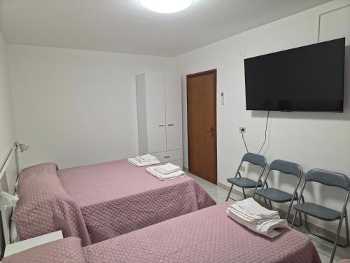 a room with two beds and a flat screen tv at Casa Vacanze Merion in Piticchio