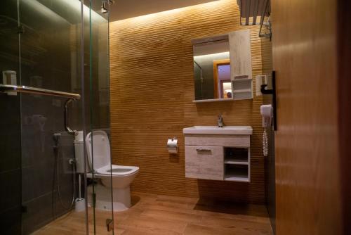 a bathroom with a toilet and a sink and a mirror at Les Roches De Mazagan in El Jadida