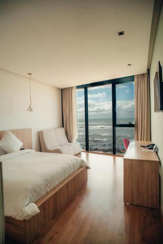 a bedroom with a bed and a view of the ocean at Les Roches De Mazagan in El Jadida