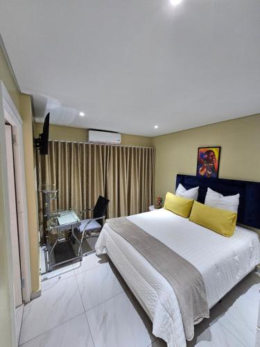 a bedroom with a large bed and a desk at Posimuma Guesthouse Boutique in Centurion