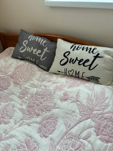 a bed with two pillows with the words mum sweet at SweetHome in Limbaži