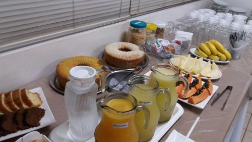 a table with food and drinks on a counter at Uniflat Hotel Bauru in Bauru