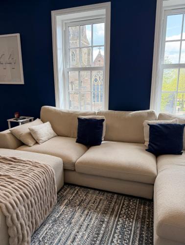 ein Wohnzimmer mit einer Couch und blauen Wänden in der Unterkunft The Loft, FlatB, Redditch in Redditch
