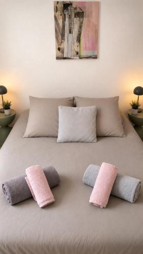 a bed with four pillows on top of it at HAPPY HOME COLMAR with PRIVATE PARKING in Colmar