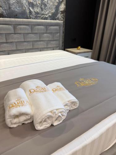 a bed with white towels on top of it at Darius Hotel in Shkodër