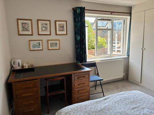 a bedroom with a desk and a bed and a window at The Windsor Room in Windsor