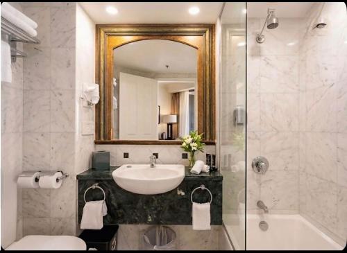 a bathroom with a sink and a mirror and a shower at Stunning City View Beachfront Apartment in Gold Coast