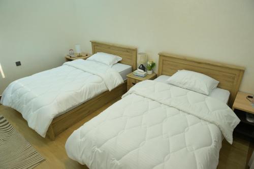 two beds sitting next to each other in a bedroom at Al Miqyal Resort - استراحة المقيال - الساد in Al Ain