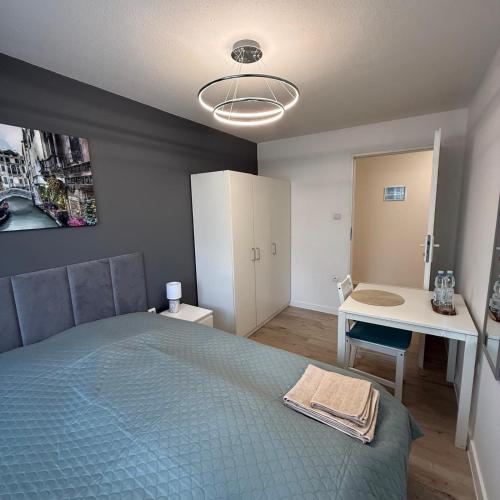 a bedroom with a bed and a table and a desk at Theo in Poznań